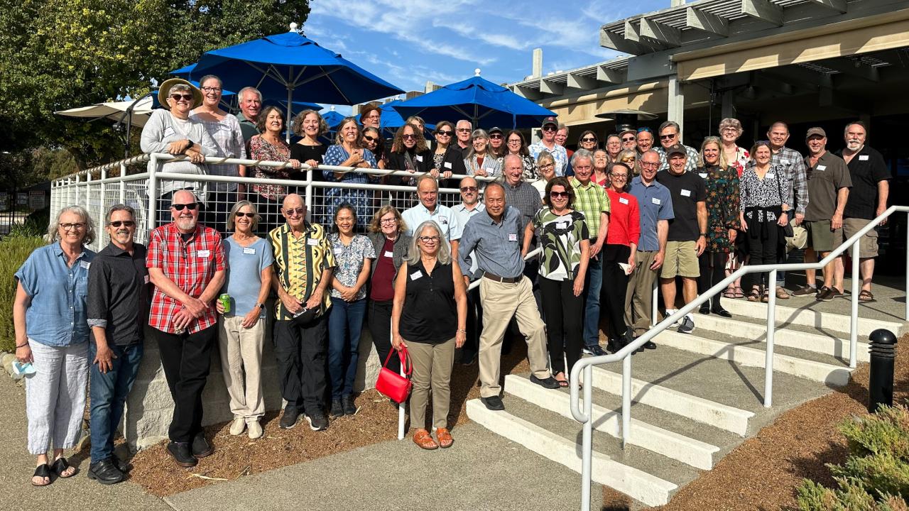 Large group of alumni gathered in front of a building