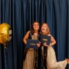 Pictured: Two students getting photographed at the end of the Spring Banquet ceremony.